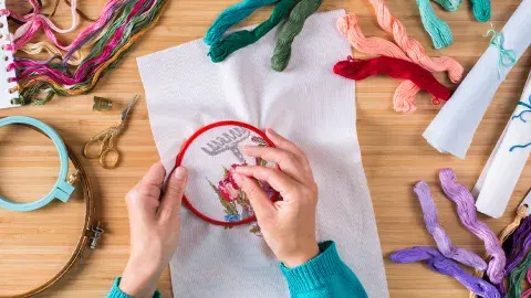 Two hands embroidering 