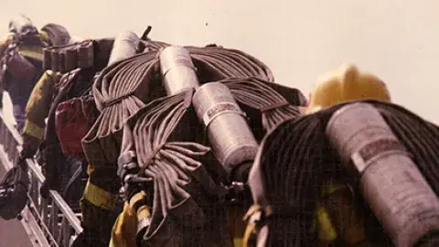 firefighters climbing ladder with equipment