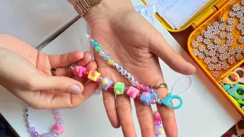 hand holding colorful bracelet beads