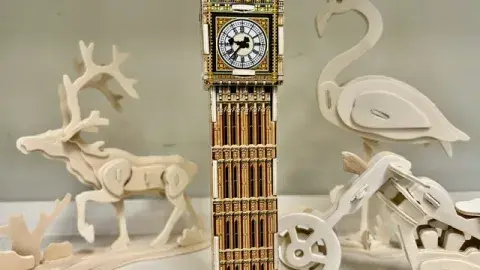 Image of a variety of 3D wooden puzzles (of animals, a building and a vehicle)
