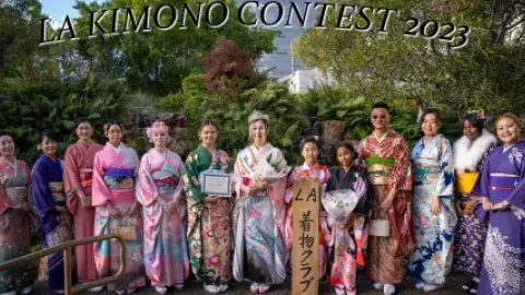 Several individuals stand in a row wearing bright kimonos
