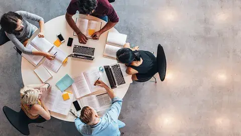 Four students are working on assignments together 