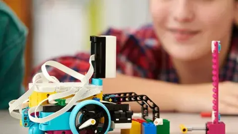 LEGO robot in foreground with a youth maker in the background.