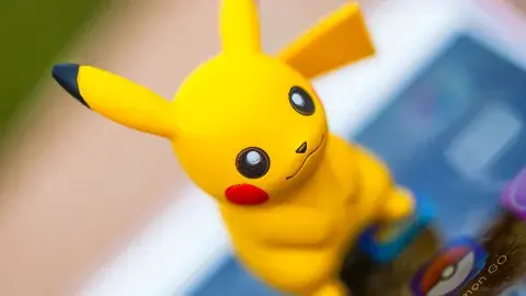 Pikachu figurine on top of a device featuring Pokemon TCG app