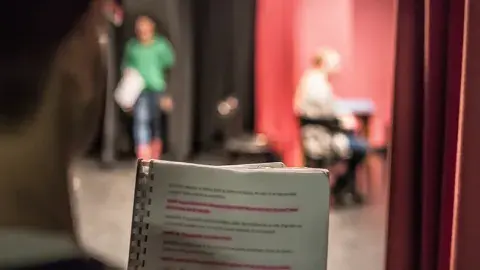 person holding a script on a stage