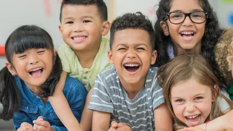 Six young children laughing.