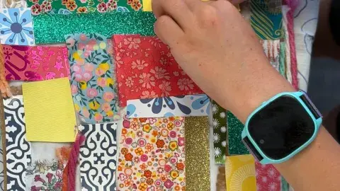 Hands work on an upcycled craft project
