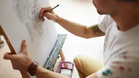 A man sketching with pencil on a pad