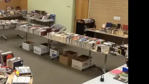 A library with boxes of books and tables of books 