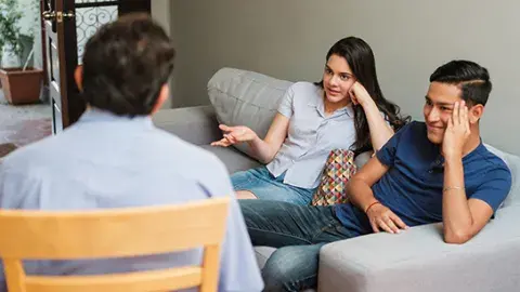 group of people sitting on couch and sofa talking