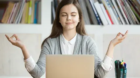 Girl Meditating in front of laptop 