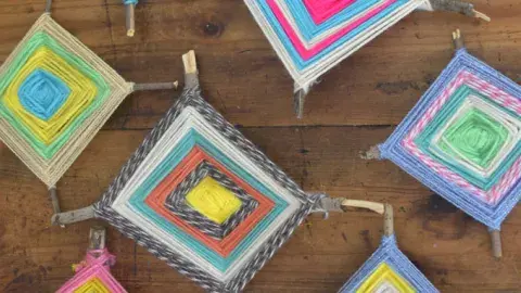 An assortment of completed Ojos de Dios in various colors. 