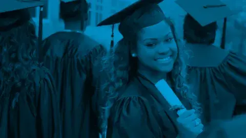 Graduates wearing caps and gowns, with one graduate holding a diploma.