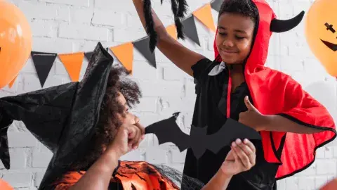 Kids in Halloween costumes play with Halloween toys