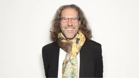 Ira Israel wearing a scarf and glasses.