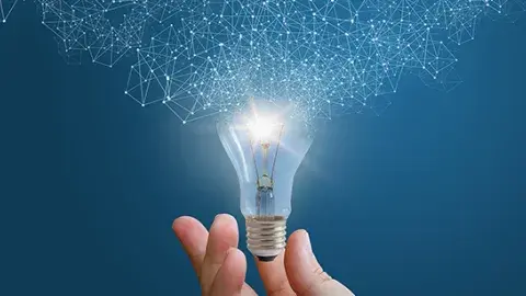 A hand hold a light bulb that is is expanding into the light
