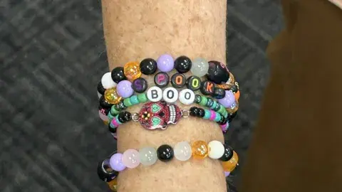 Colorful friendship bracelets on a wrist.