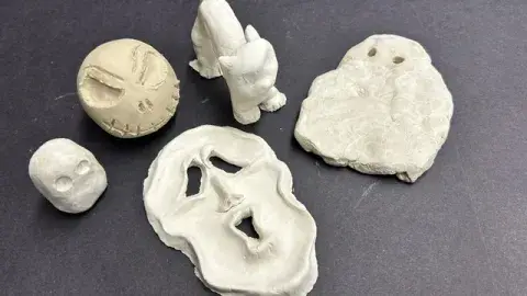 Five different clay creations: two ghosts, a halloween cat, and two scary faces.