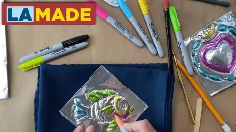 a set of hands coloring in a piece of tin work