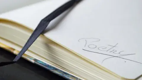 Close-up of a page in a journal with the word poetry written in it.