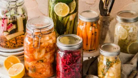 A spread of mason jars containing different fermented vegetables.