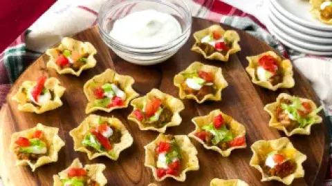 Mini Tacos on Wood Serving Tray with Sour Cream in a dish and plates