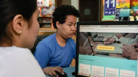 Two teens using computers.