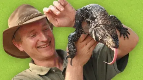 Man holding up a reptile