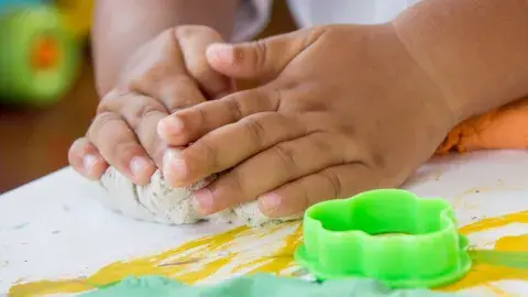 children's hands play with clay