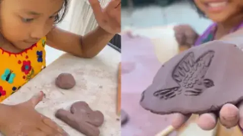 Children playing with clay. A child holds clay with an imprint of a bird in their hand.