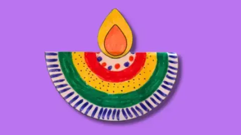 A colorful paper diya on a purple background.