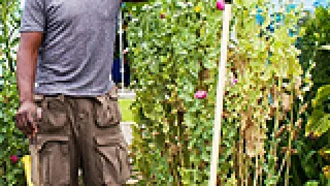 Ron Finley in a garden holding a rake