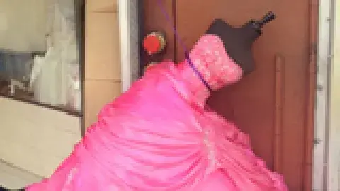 bright pink dress on a dress form fallen over in the street