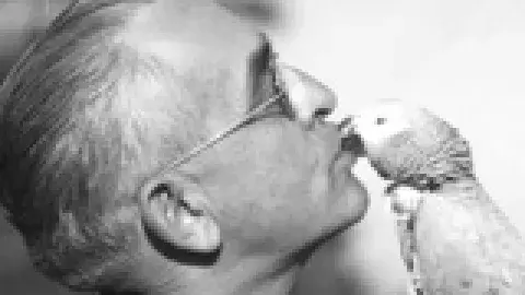 odler man kissing a parrot
