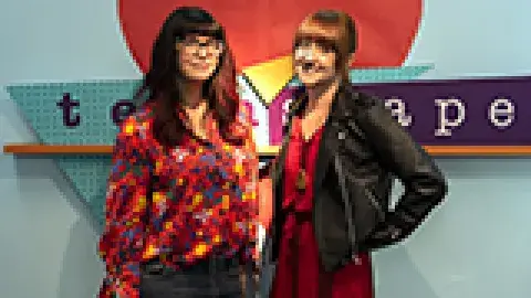 2 women in front of the teenscape sign
