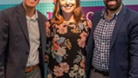 2 men and a woman smiling with their arms around each other