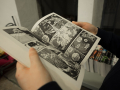 close up of hands holding open a manga book