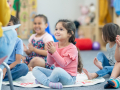 Toddlers seated on the floor listening to a story