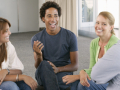 Group of adults sitting in chairs in a circle having a lively conversation