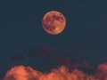 moon on dark night sky with red clouds