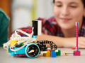Image of LEGO robot in foreground with a blurred image of a youth maker in the background.