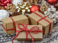 Brown packages tied with red string, with holiday decorations in the background, Image by Monika from Pixabay