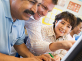 Mature students learning computer skills in a classroom.