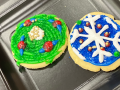 Two decorated cookies on a black plate