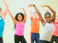 Children are waiving their arms while exercising.