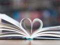 Picture of an open book with the middle pages making the shape of a heart. 