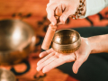 A person striking a sound bowl.