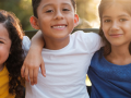 young children girls and boys smiling with arms around each other
