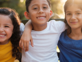 young children girls and boys smiling with arms around each other