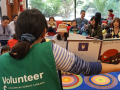 Volunteer reading to children sitting on a rug in a library!